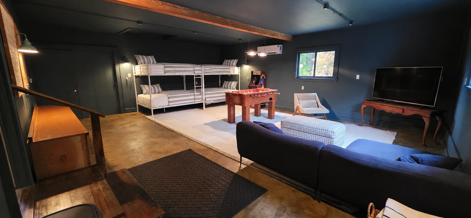 Bunk lounge with neatly made bunks, seating, and a foosball table