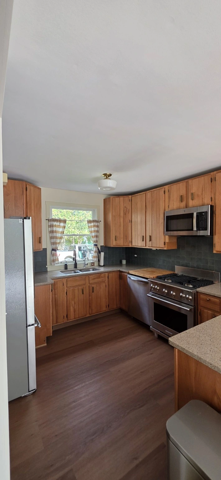 Gourmet kitchen with a gas range, stainless appliances and wood cabinets